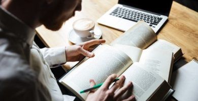 Hombre leyendo varios libros